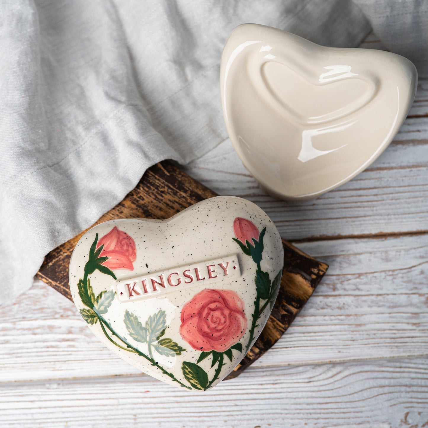 Top view of the ceramic heart urn, showing the detailed rose petals and botanical leaf accents.