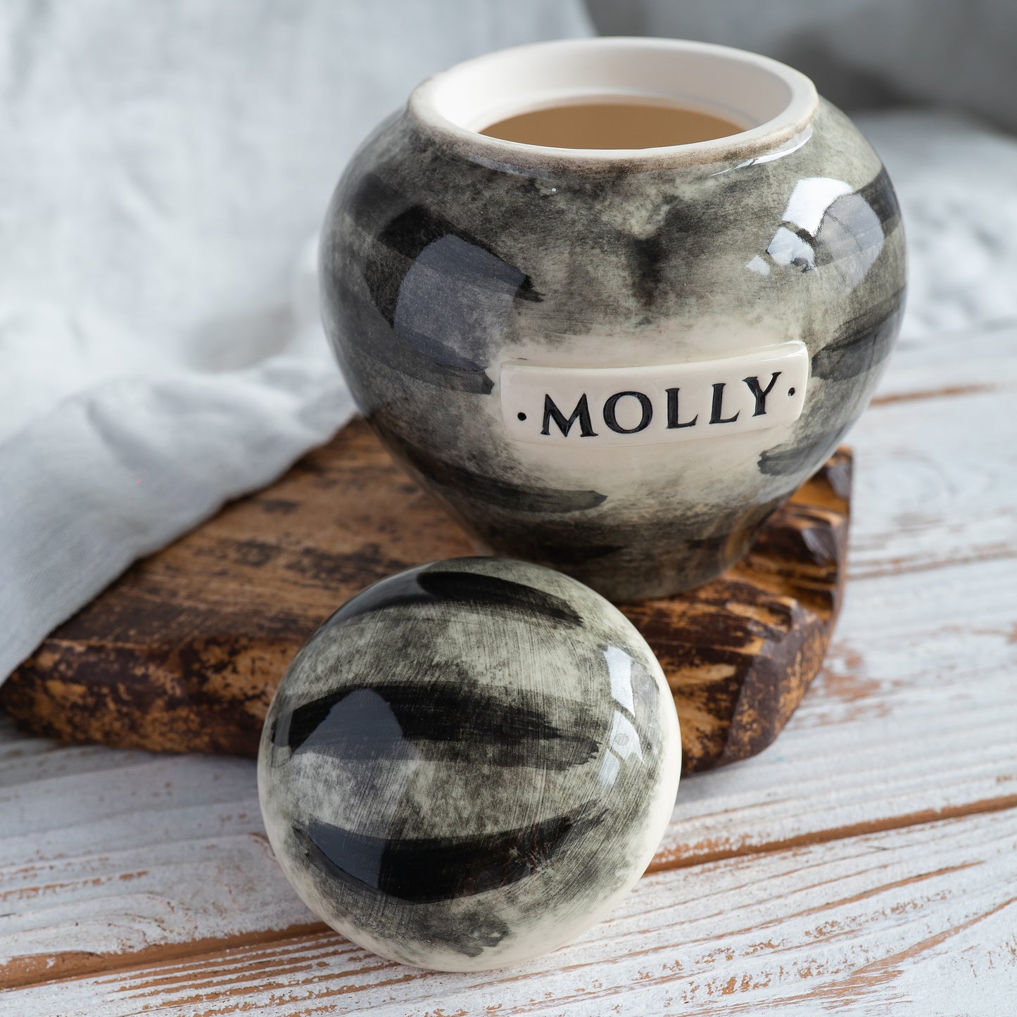 Top-down view of the open heart-shaped cat urn, showing grey striped pattern on the lid.