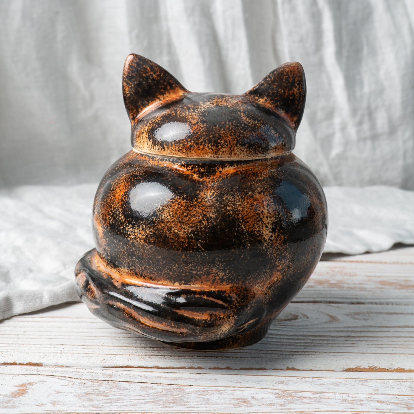 Back  view of hand-painted tortie cat ceramic pet memorial urn showing mottled fur pattern and tail details