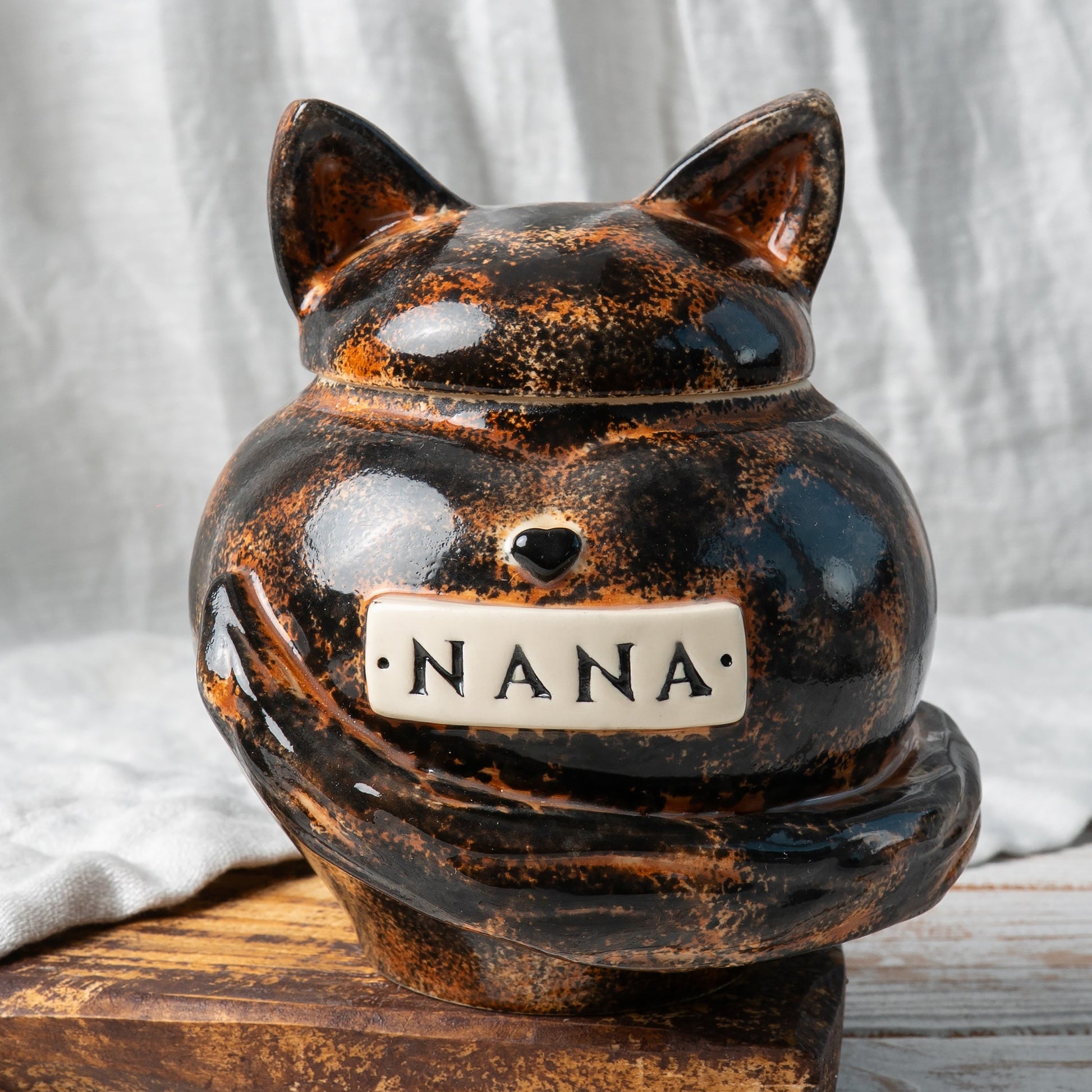 Tortoiseshell cat heart-shaped ceramic urn for ashes with sculpted cat ears and tail front view