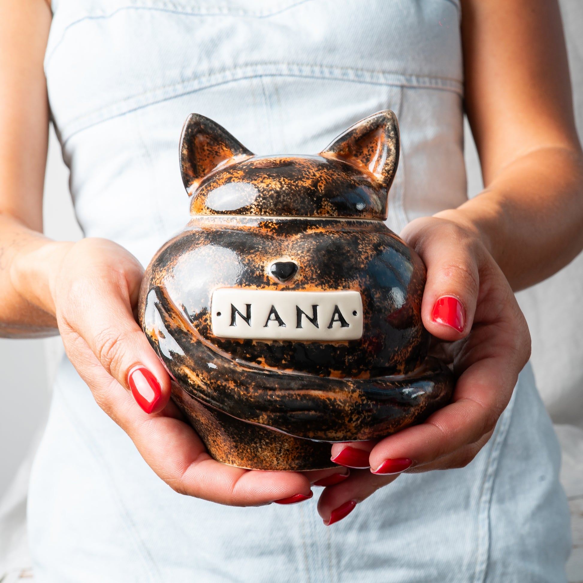 Small custom heart ceramic tortoiseshell cat keepsake urn held gently in hands for scale