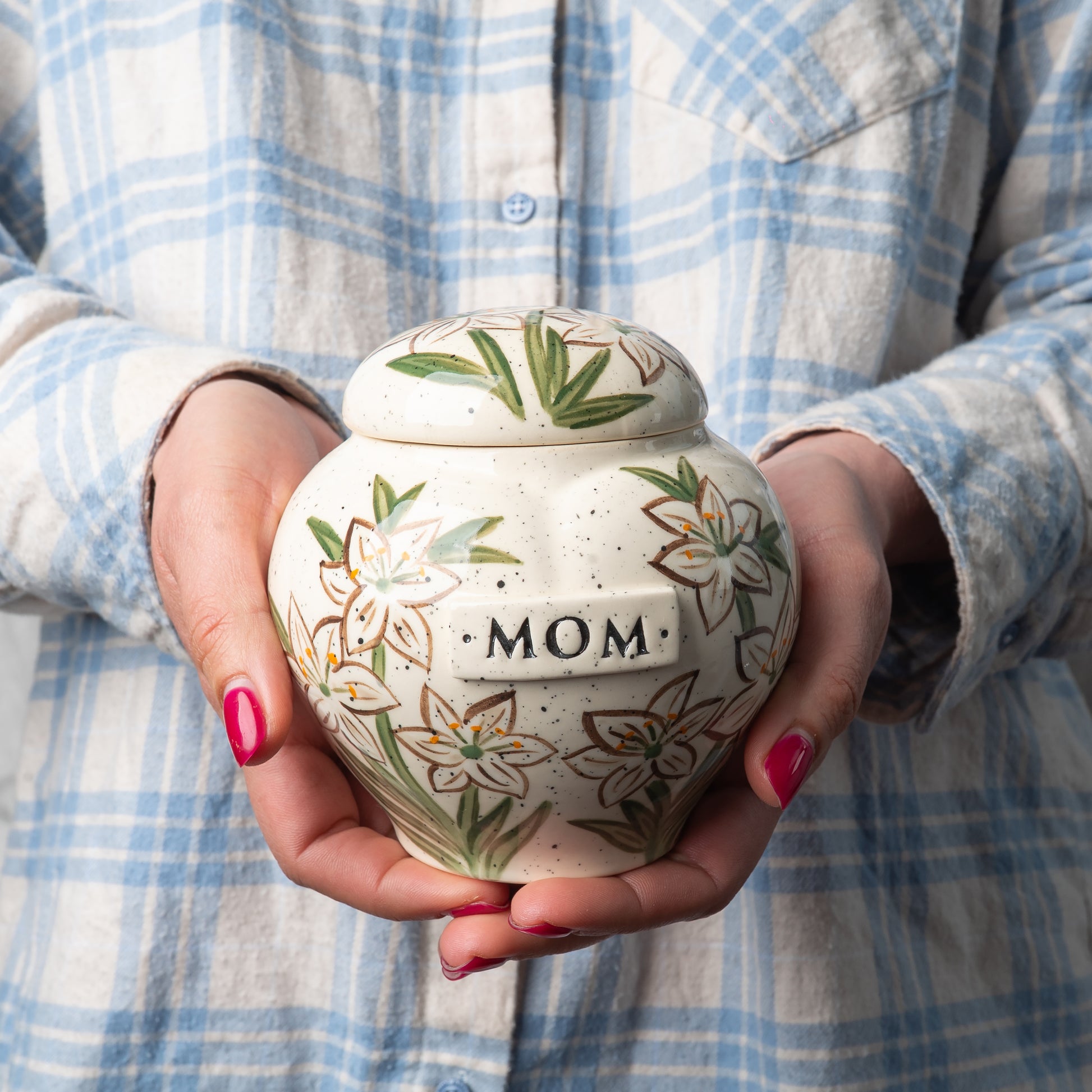 Small custom heart ceramic white lily keepsake urn held gently in hands for scale