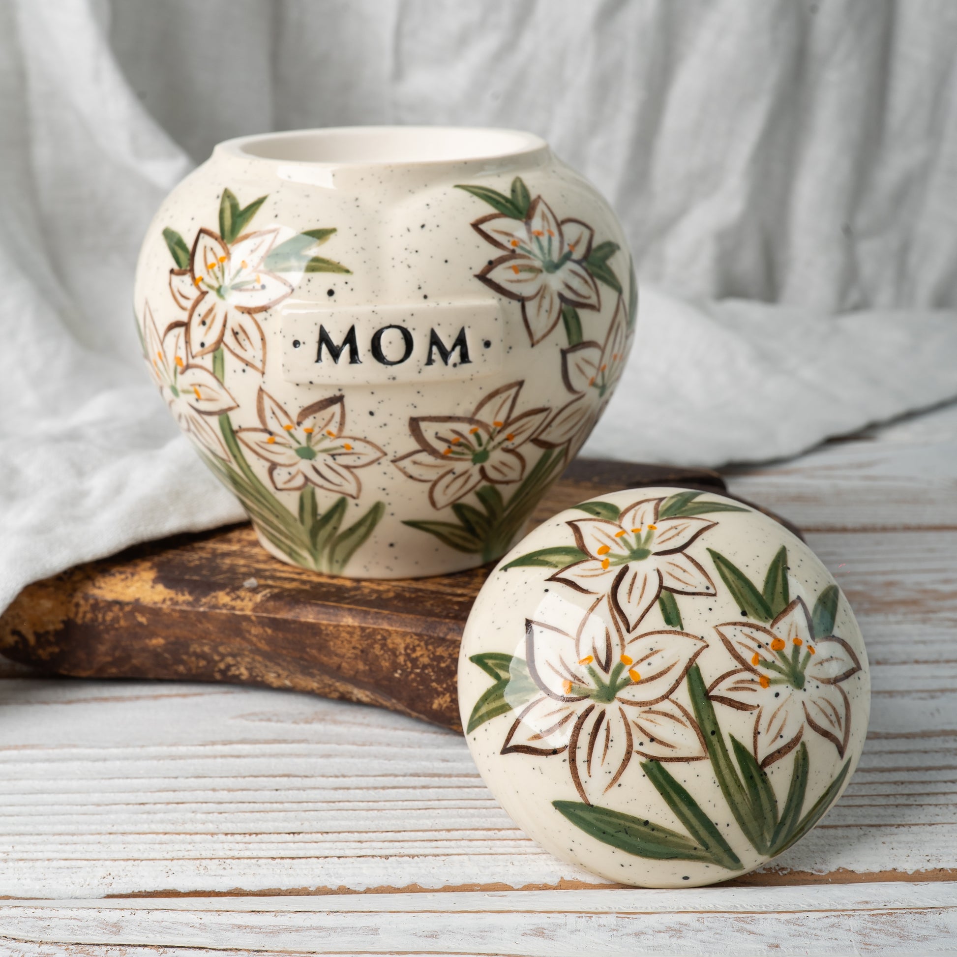 Custom white lily flower ceramic urn shown open revealing inner chamber for ashes